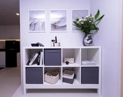 a white book shelf with a vase of flowers at апартаменты с двумя спальнями in Karon Beach