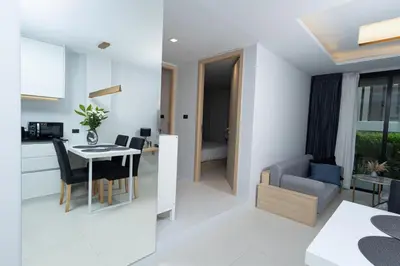 a kitchen and a living room with a table and chairs at апартаменты с двумя спальнями in Karon Beach