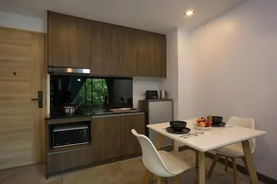 a kitchen with a white table and chairs and a counter at Duplex Loft near Nai Harn Beach with Pools & Gym - Utopia Loft B125 in Rawai Beach