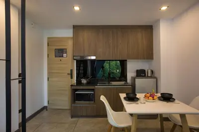 a kitchen with a white table and chairs in a room at Duplex Loft near Nai Harn Beach with Pools & Gym - Utopia Loft B125 in Rawai Beach