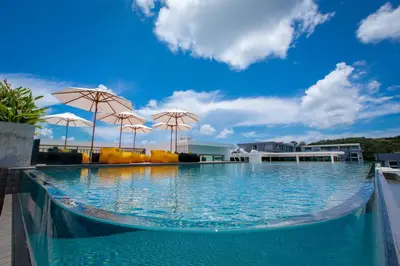 a large swimming pool with umbrellas on top of it at Duplex Loft near Nai Harn Beach with Pools & Gym - Utopia Loft B125 in Rawai Beach