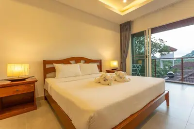 a bedroom with a bed with two stuffed animals on it at C126 Walk to Beach Global & Local Eats Pool & Gym in Rawai Beach