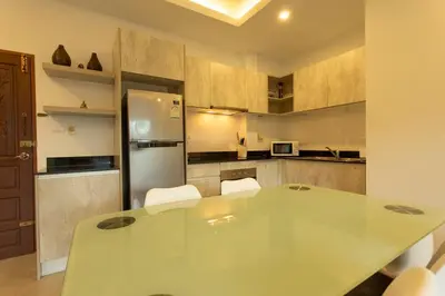 a kitchen with a glass table and white chairs at C126 Walk to Beach Global & Local Eats Pool & Gym in Rawai Beach