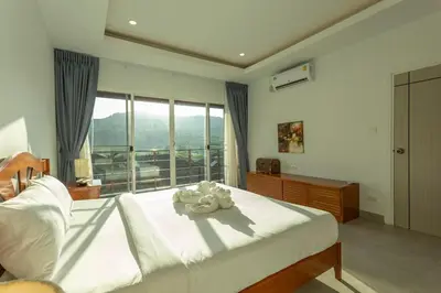 a bedroom with a bed and a large window at C126 Walk to Beach Global & Local Eats Pool & Gym in Rawai Beach