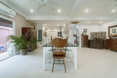 a dining room with a white table and a chair at Koson Elegant 3 Bedroom Villa in Rawai Beach