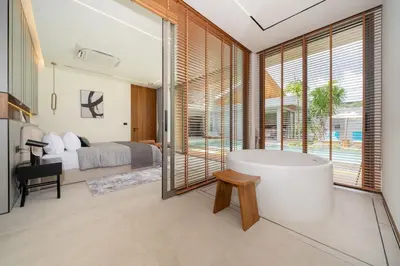 a bathroom with a tub and a bedroom with a bed at Zenithy Morden Pool and Garden Villa near Bangtao Beach in Ban Pak Lak