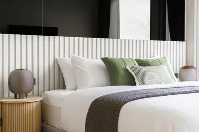 a bedroom with a bed with white and green pillows at The Ozone Lounge Lovers Golf View Bangtao in Laguna Phuket