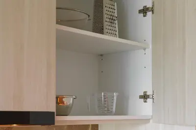 a kitchen cabinet with shelves with bowls and utensils at The Ozone Lounge Lovers Golf View Bangtao in Laguna Phuket