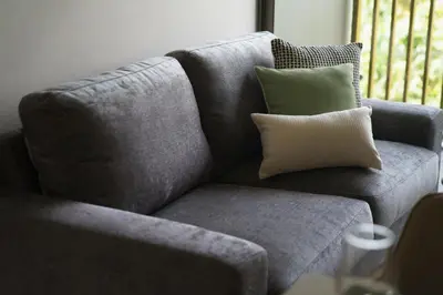a gray couch with two pillows on top of it at The Ozone Lounge Lovers Golf View Bangtao in Laguna Phuket