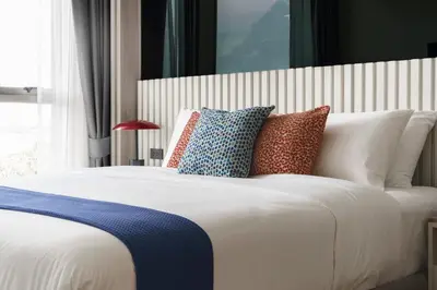 a large bed with many pillows on it at The Ozone Catisse Golf View Bangtao in Laguna Phuket