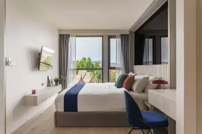 a bedroom with a bed and a large window at The Ozone Catisse Golf View Bangtao in Laguna Phuket
