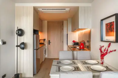 a kitchen with a table with white plates on it at The Ozone Catisse Golf View Bangtao in Laguna Phuket