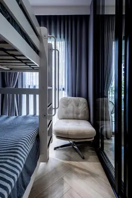 a bedroom with a bunk bed and a chair at The Legenda Bang Tao in Bang Tao Beach