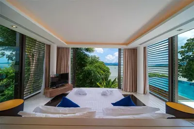 a bedroom with a large bed and large windows at Villa Elegance Luxury Ocean View Pool Villa with Breakfas & Daily Maid Service in Ko Lek