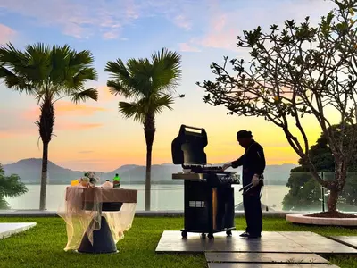 a man standing in front of a grill at Villa Elegance Luxury Ocean View Pool Villa with Breakfas & Daily Maid Service in Ko Lek