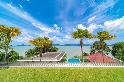 a house with a view of the water and palm trees at Villa Elegance Luxury Ocean View Pool Villa with Breakfas & Daily Maid Service in Ko Lek
