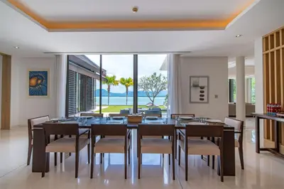 a dining room with a table and chairs and a large window at Villa Elegance Luxury Ocean View Pool Villa with Breakfas & Daily Maid Service in Ko Lek