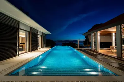a swimming pool in the middle of a house at night at Villa Elegance Luxury Ocean View Pool Villa with Breakfas & Daily Maid Service in Ko Lek