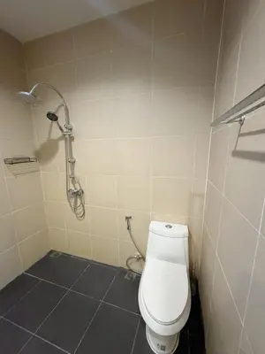 a bathroom with a toilet and a shower at shine bright villa in Ban Saiyuan (1)