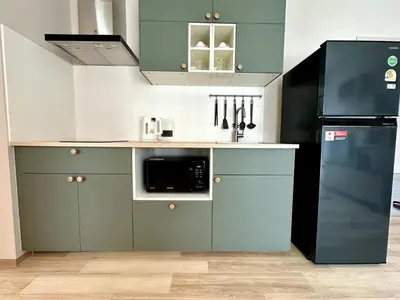 a kitchen with blue cabinets and a black refrigerator at Beatiful titlhalo apartment in Nai Yang Beach