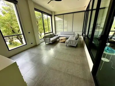 a living room with a couch and chairs and windows at Beatiful titlhalo apartment in Nai Yang Beach