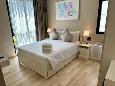a bedroom with a white bed with towels on it at Beatiful titlhalo apartment in Nai Yang Beach