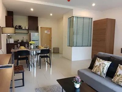 a living room and kitchen with a couch and a table at A Well Equipped Condo near Karon Beach in Karon Beach