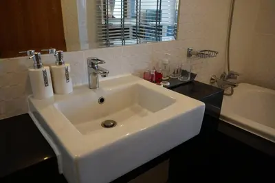 a bathroom with a white sink and a bath tub at A Well Equipped Condo near Karon Beach in Karon Beach