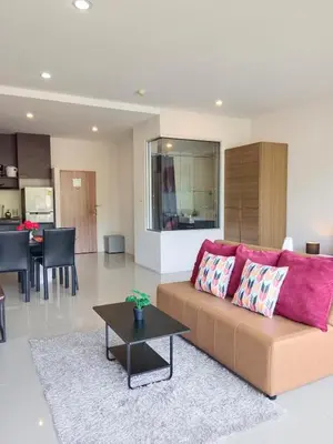 a living room with a couch and a table at A Well Equipped Condo near Karon Beach in Karon Beach