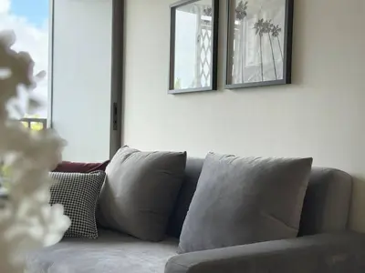 a living room with a gray couch with two mirrors at The Ozone Scarlet Grey Golf View Bangtao in Laguna Phuket