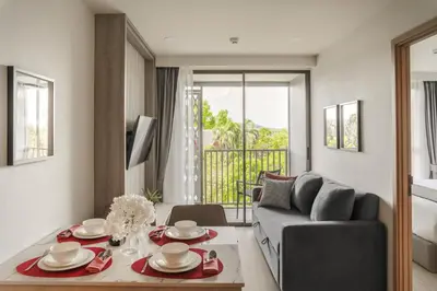a living room with a couch and a table at The Ozone Scarlet Grey Golf View Bangtao in Laguna Phuket