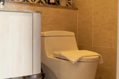a bathroom with a toilet with a towel on it at The Ozone Scarlet Grey Golf View Bangtao in Laguna Phuket
