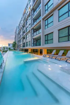 an empty swimming pool in front of a building at RJ Space in Ban Thalat Choeng Thale