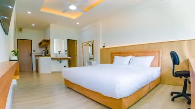 a bedroom with a large white bed and a kitchen at Quiet & Comfy studio - Walk to Rawai Beach - 