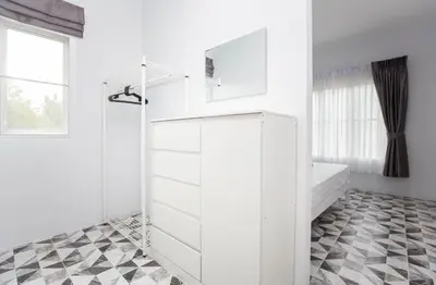 a bathroom with white cabinets and a checkered floor at Seaside house in Ban Thalat Choeng Thale