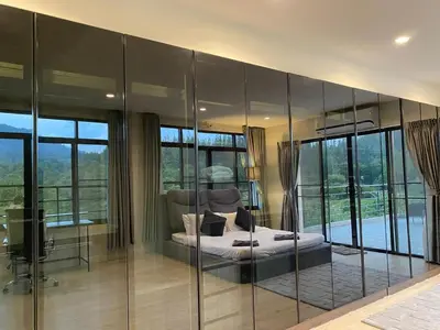 a bedroom with a bed and glass walls at 5BR Lucky Pool Villa Kathu Golf - 12 guest in Kathu