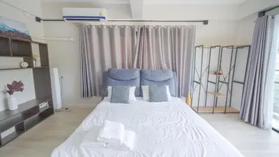 a bedroom with a large white bed with blue pillows at 5BR Lucky Pool Villa Kathu Golf - 12 guest in Kathu