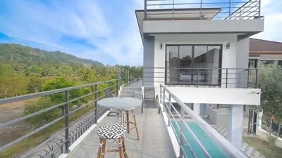 a balcony of a house with a table and two stools at 5BR Lucky Pool Villa Kathu Golf - 12 guest in Kathu