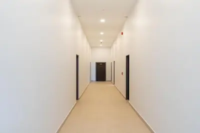 an empty corridor in an office building with white walls at DC Resident Phuket in Phuket Town