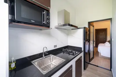 a kitchen with a sink and a microwave at DC Resident Phuket in Phuket Town