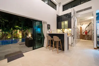 a kitchen with a bar and stools in a house at Noi's Villa - tropical oasis with pool and maid in Kamala Beach