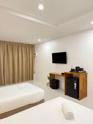 a hotel room with two beds and a flat screen tv at Veeyava Bangtao House in Surin Beach