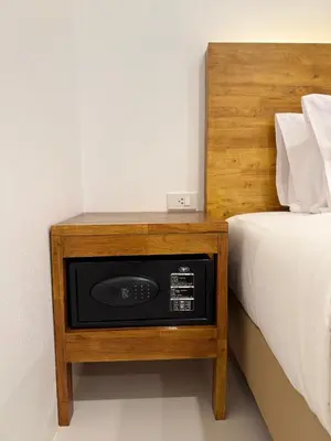 a bed and a night stand next to a bed at Veeyava Bangtao House in Surin Beach