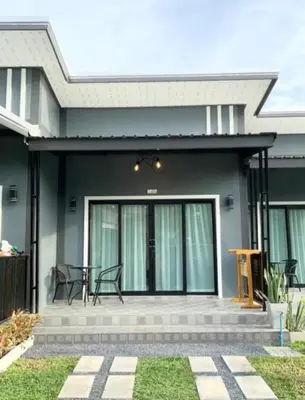 a house with a front porch with black chairs at Veeyava Bangtao House in Surin Beach
