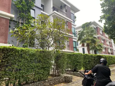 a man riding a motorcycle in front of a building at The title rawai in Ban Saiyuan (1)