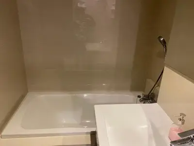 a bathroom with a white tub and a sink at The title rawai in Ban Saiyuan (1)