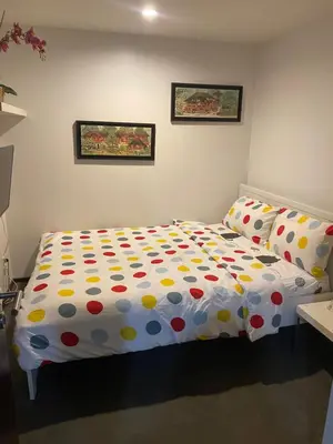 a bedroom with a bed with a polka dot bedspread at The title rawai in Ban Saiyuan (1)