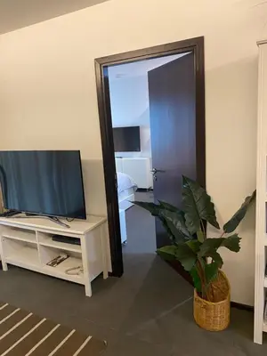 a living room with a television and a mirror at The title rawai in Ban Saiyuan (1)