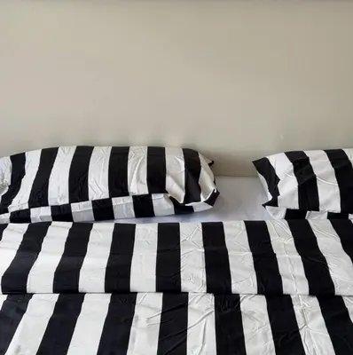 a bed with black and white sheets and pillows at bége in Ban Lo Long