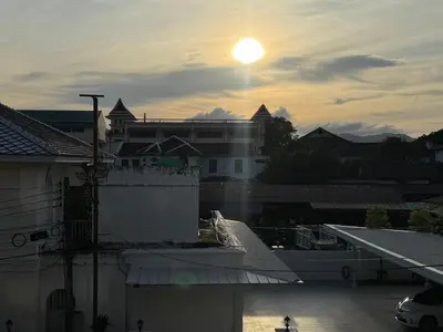 a view of a building with the sunset in the background at bége in Ban Lo Long